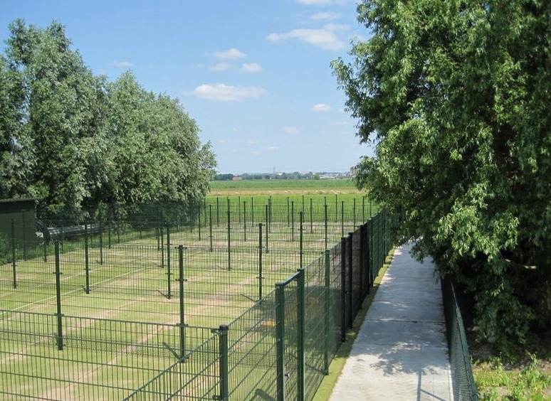 Overzicht van de omheinde speelweides met uitzicht over het open land