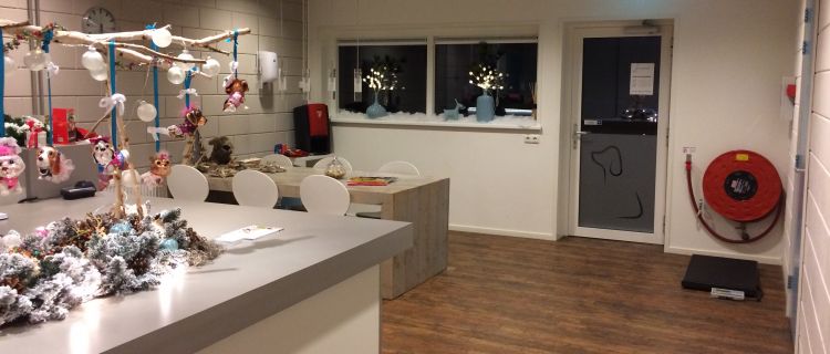 De ontvangstruimte met decoratie, een slanghaspel en de deur naar de verblijven